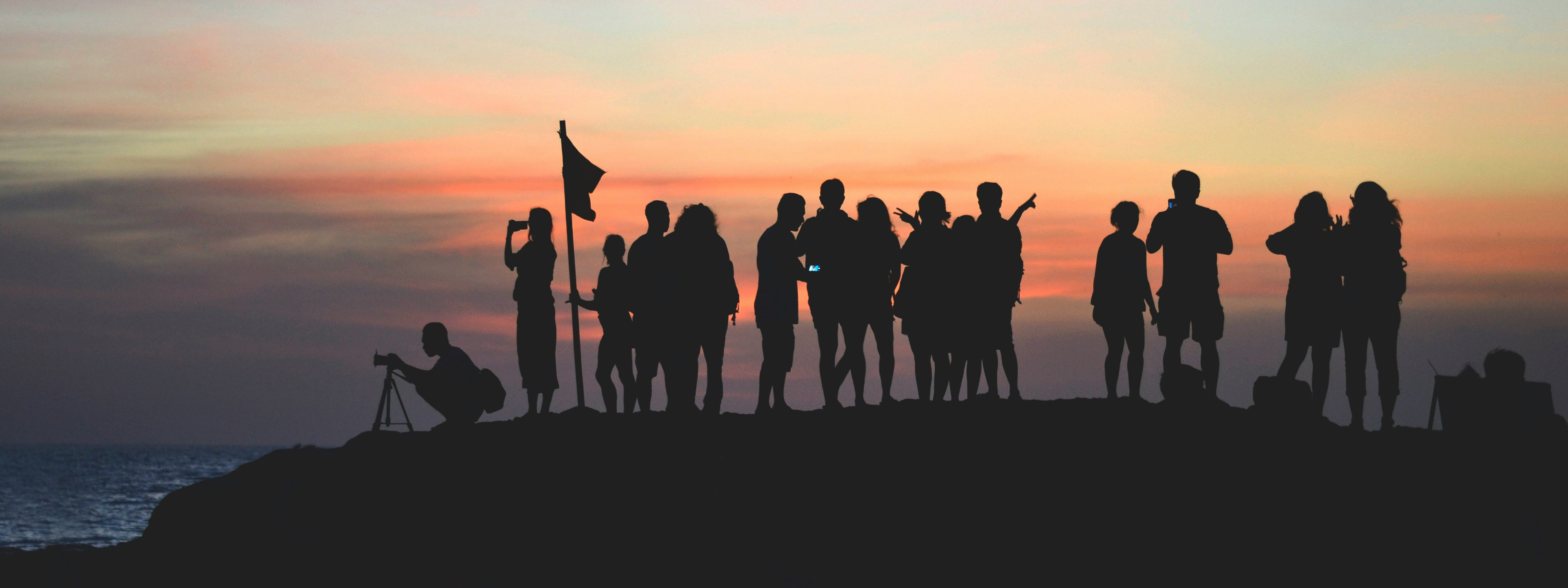 A team group of people at the beach at sunset
